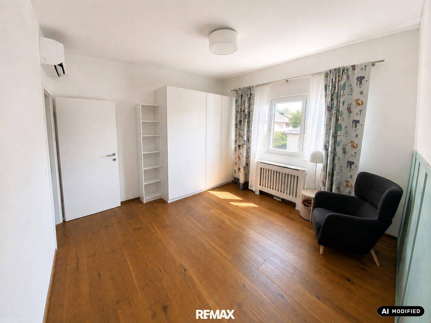 Geräumiges Schlafzimmer mit Holzboden, Sessel und Fenster.