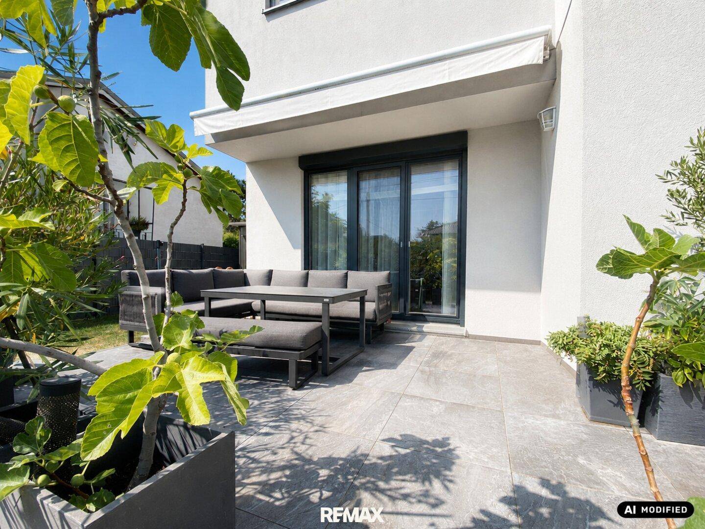 Gemütliche Terrasse mit modernen Gartenmöbeln und Pflanzen.
