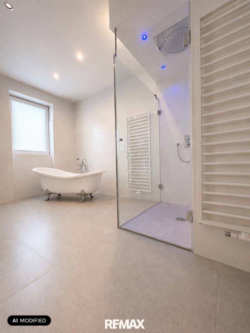 Modernes Badezimmer mit freistehender Badewanne, begehbarer Dusche und beheiztem Handtuchhalter.