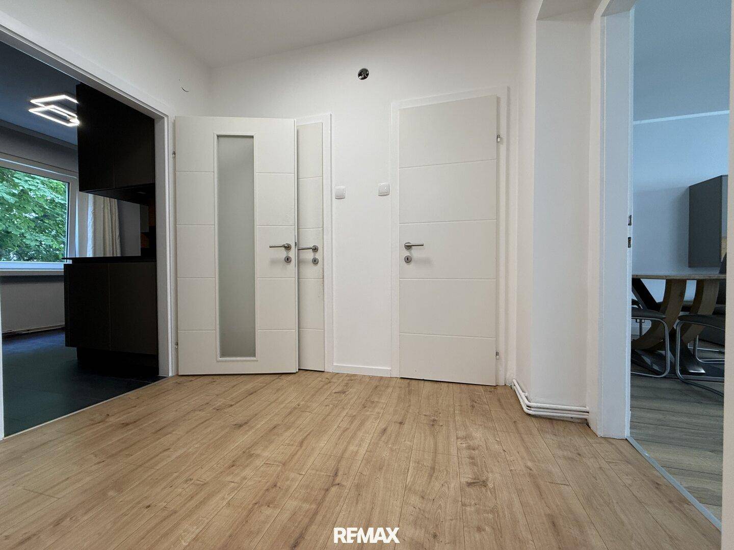 Heller Flurbereich mit Holzboden und Zugang zu verschiedenen Zimmern der Wohnung.