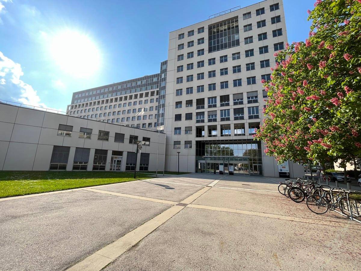 Gesamtansicht eines großen, modernen Bürokomplexes mit Grünflächen und Fahrradständern im Vordergrund.