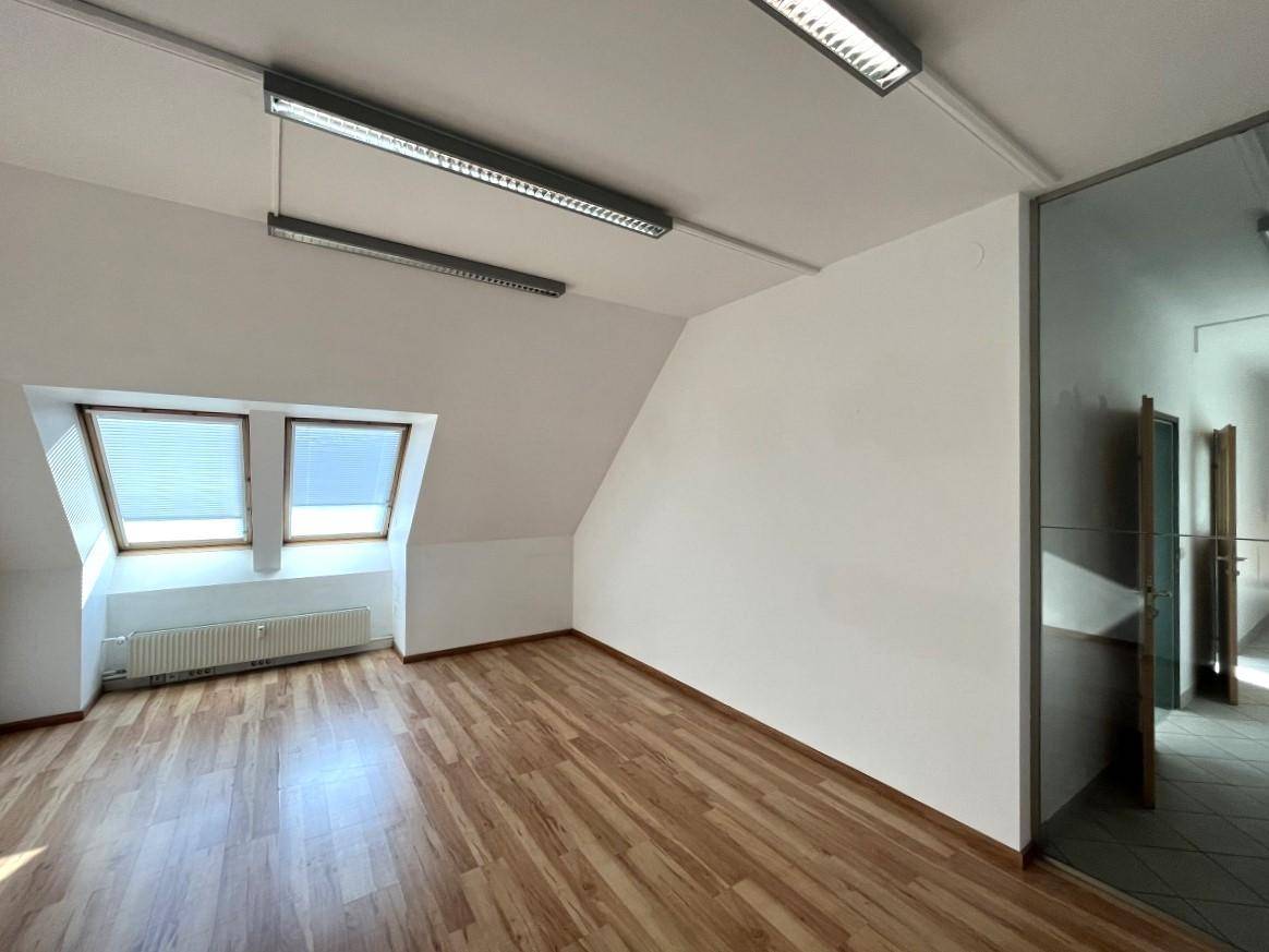 Dachbodenraum mit Laminatboden, Dachfenstern und Glastür zu einem weiteren Bereich.