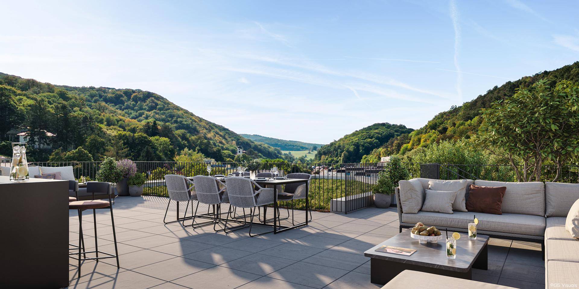 Geräumige Dachterrasse mit modernen Lounge-Möbeln und weitem Blick über die bewaldeten Hügel.
