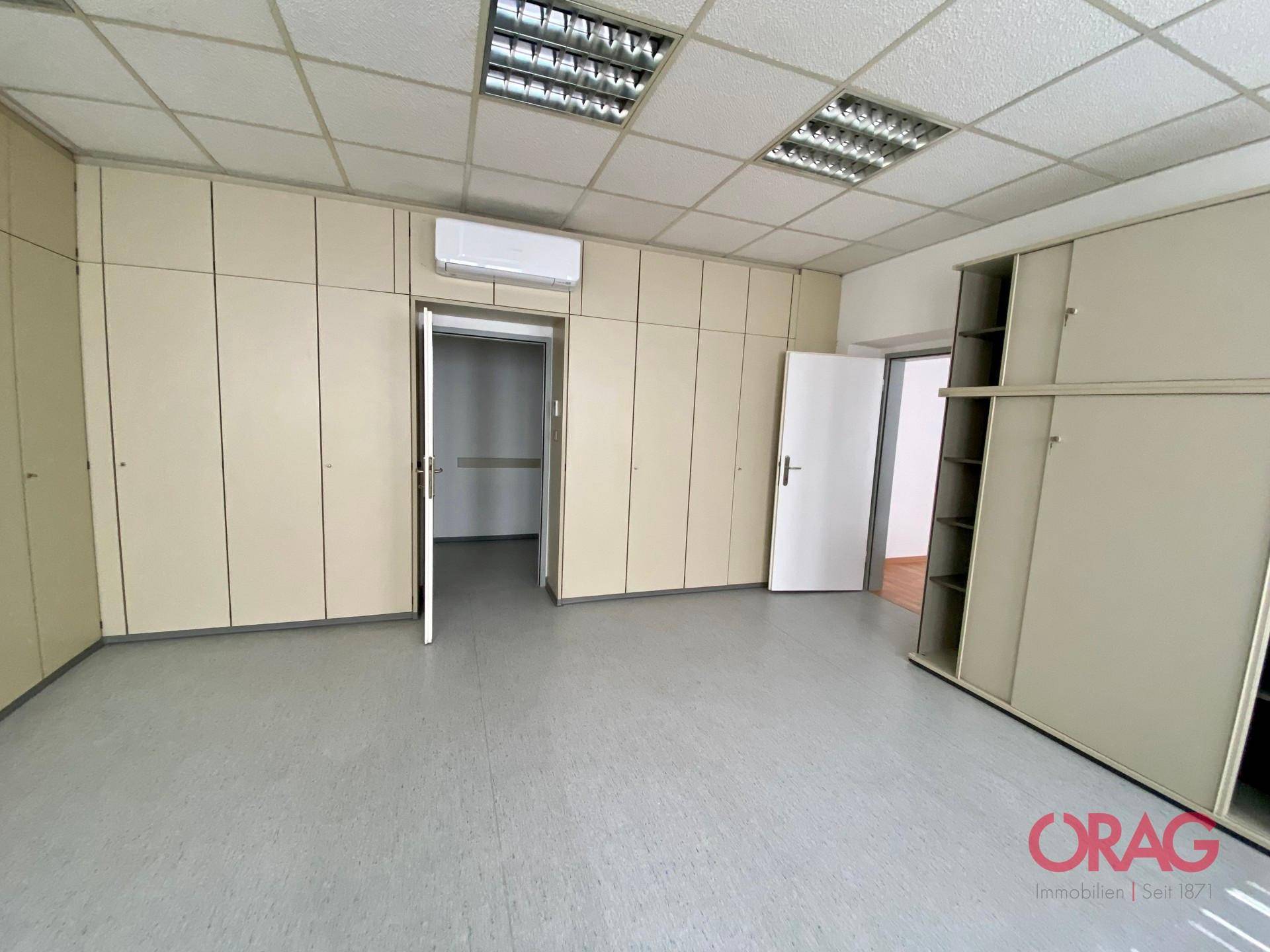 Büro mit vielen Einbauschränken, Klimaanlage und Zugang zu weiteren Räumen.