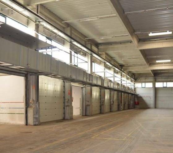 Innenansicht einer Lagerhalle mit einer langen Reihe von internen Laderampen und Rolltoren.
