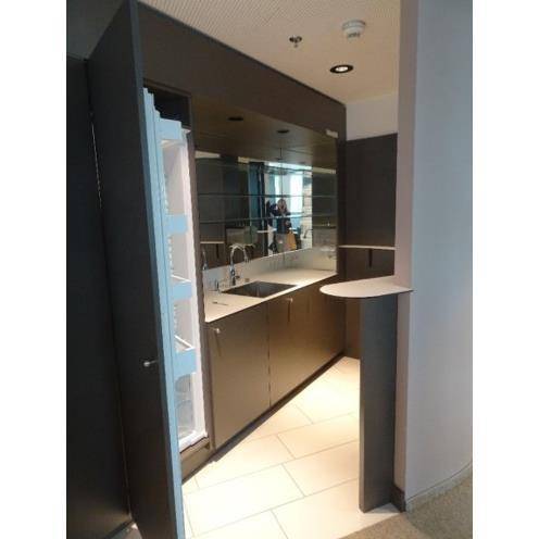 Kompakte Küchenzeile mit Spüle, Kühlschrank und Ablageflächen, ideal für schnelle Erfrischungen.