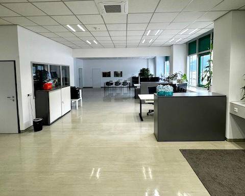 Geräumiges Großraumbüro mit modernen Arbeitsplätzen, Stauraum und großen Fenstern für viel Tageslicht.