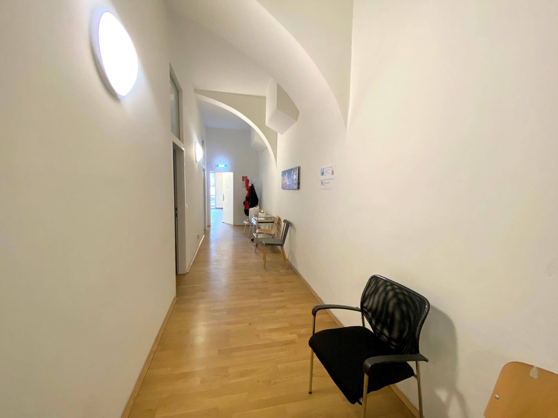 Langer Flur mit gewölbter Decke, Holzboden und natürlichem Lichteinfall.