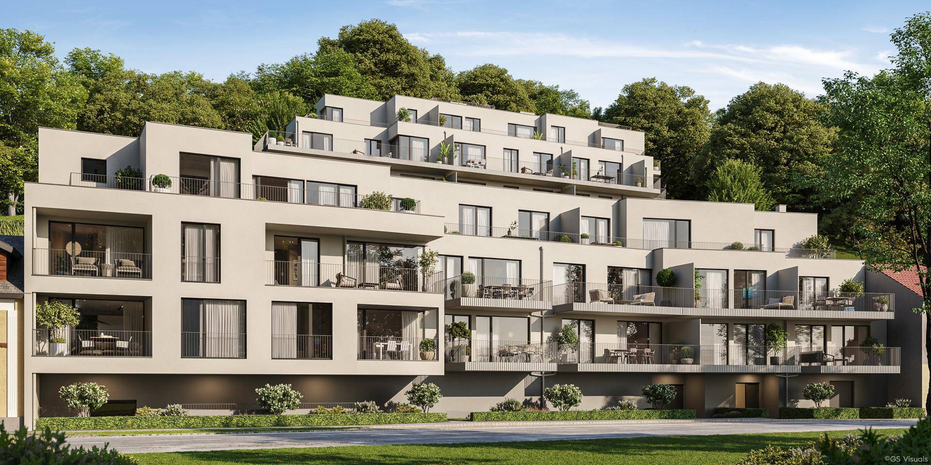 Moderne Architektur mit gestuften Terrassen und Balkonen, harmonisch in die grüne Hanglandschaft integriert.