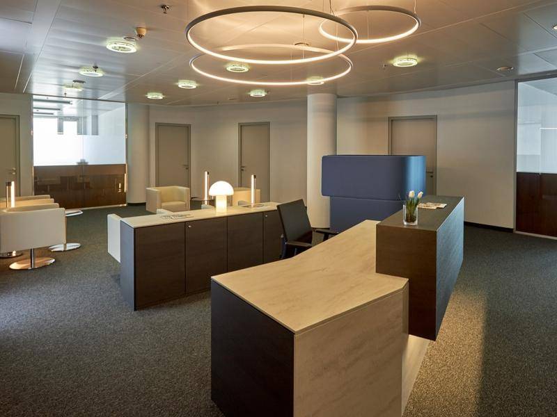 Heller Empfangsbereich mit modernem Design, Teppichboden und stilvollen Möbeln.