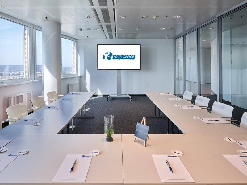 Geräumiger Konferenzraum mit flexibler Tischordnung, Teppichboden und Panoramablick.