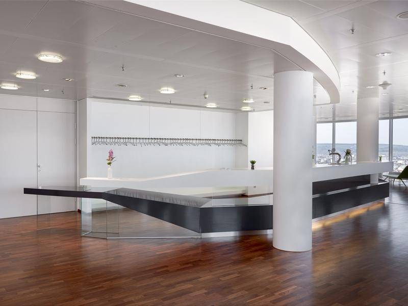 Geräumiger Lounge-Bereich mit Holzboden, moderner Bar und Panoramablick auf die Stadt.