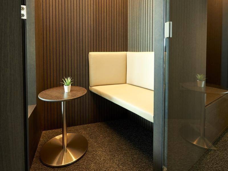 Gemütliche, schallgedämmte Nische mit Sitzbank und kleinem Beistelltisch für private Gespräche.