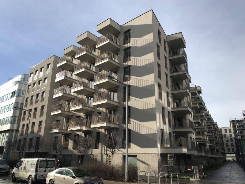 Modernes Mehrfamilienhaus mit zahlreichen Balkonen und einer zeitgenössischen Architekturfassade in einer städtischen Umgebung.