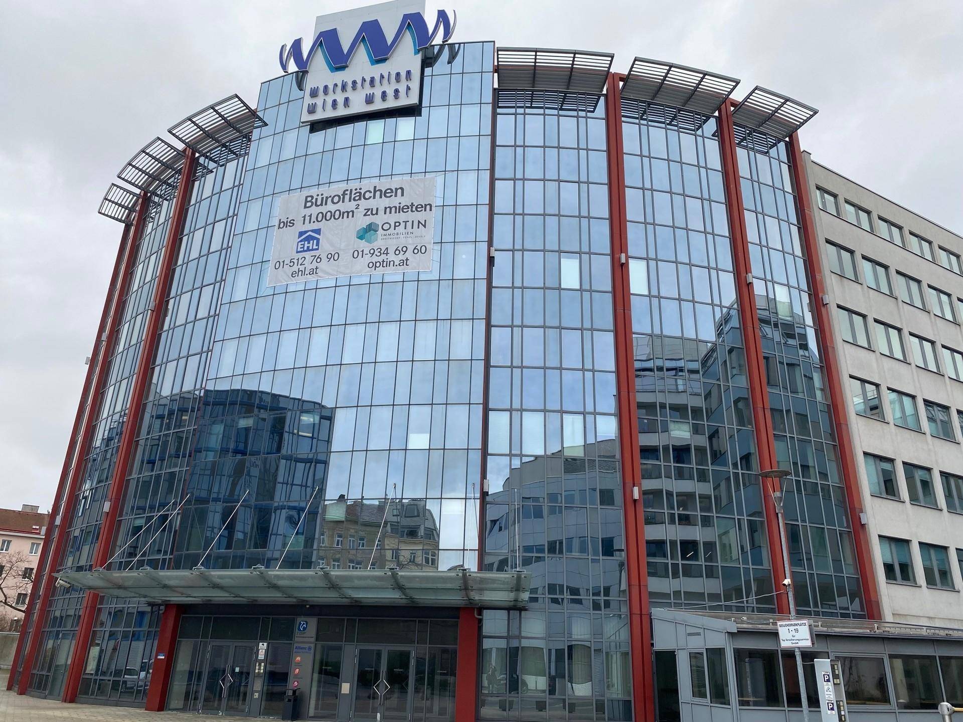 Modernes Bürogebäude mit Glasfassade und reflektierenden Fenstern, das Büroflächen zur Miete anbietet.