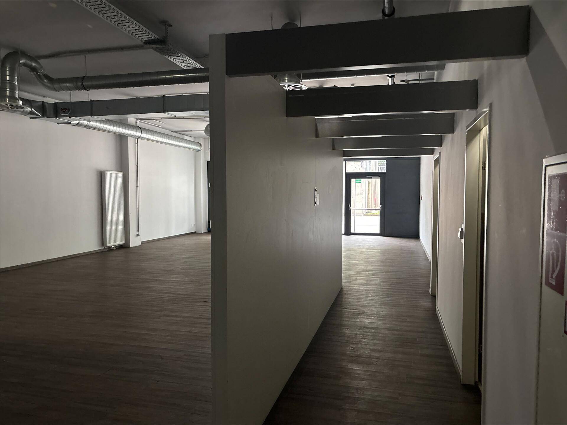 Langer Flur in einem Gewerbeobjekt mit Holzboden und Zugang zu weiteren Räumen.
