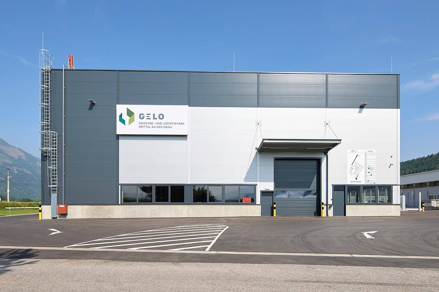 Ansicht der modernen Fassade eines Gewerbe- und Logistikparks mit Laderampe und Firmenlogo.