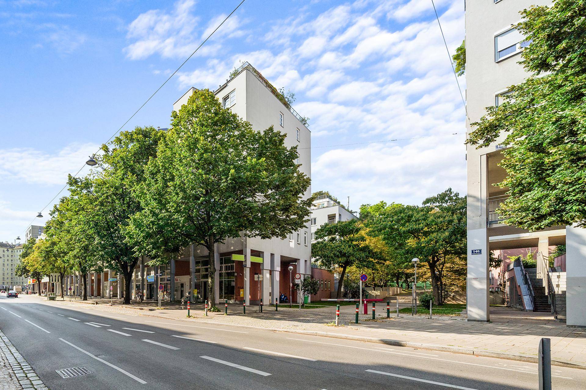 Moderne Wohngebäude mit großen Fenstern und begrünten Dächern entlang einer städtischen Straße.