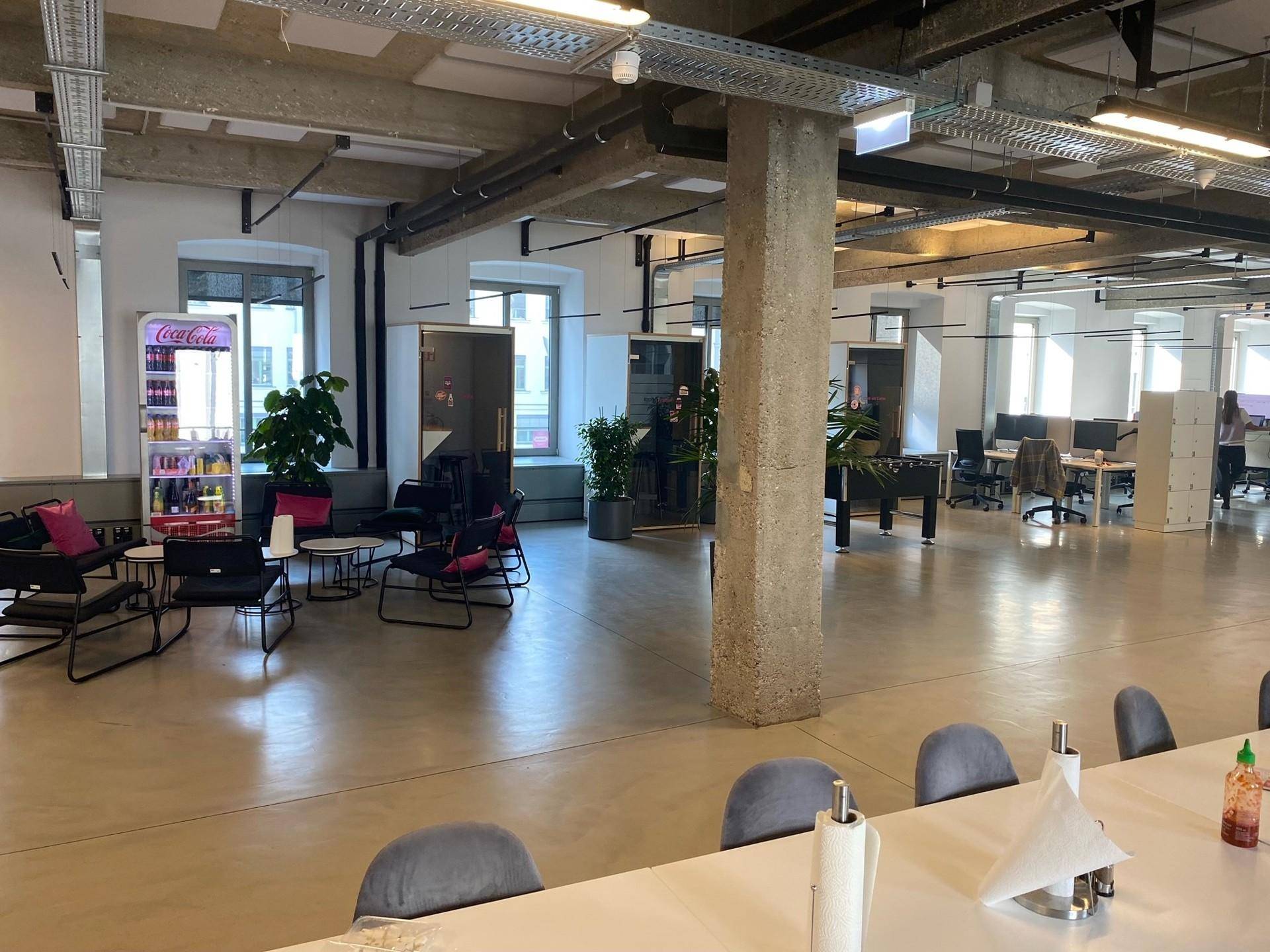 Offener Bürobereich mit Lounge-Ecke, Pflanzen und einem Tischfußballspiel für Mitarbeiter.