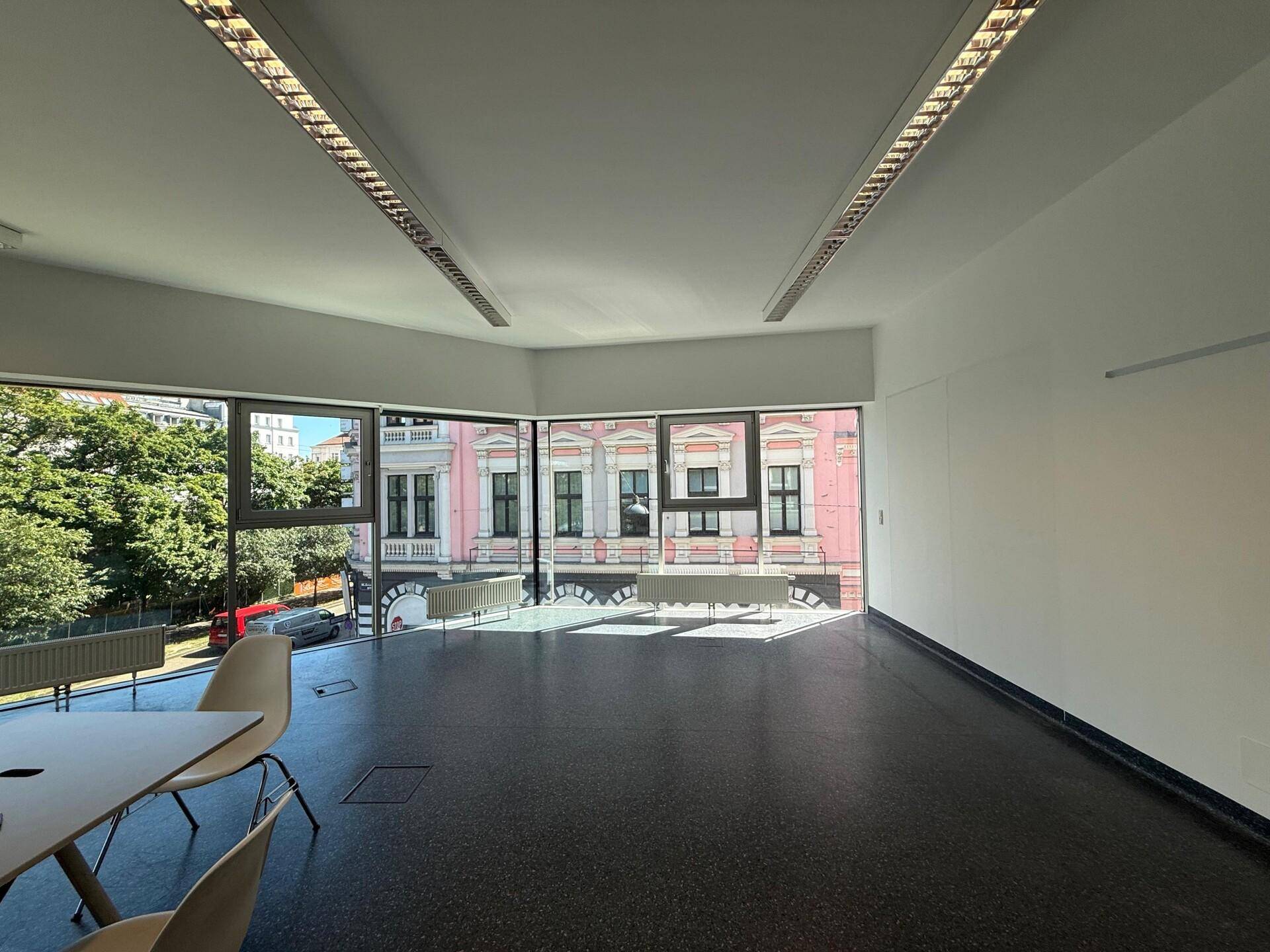Geräumiges Büro mit großen Fenstern, die viel Tageslicht hereinlassen und Blick auf die Straße bieten.
