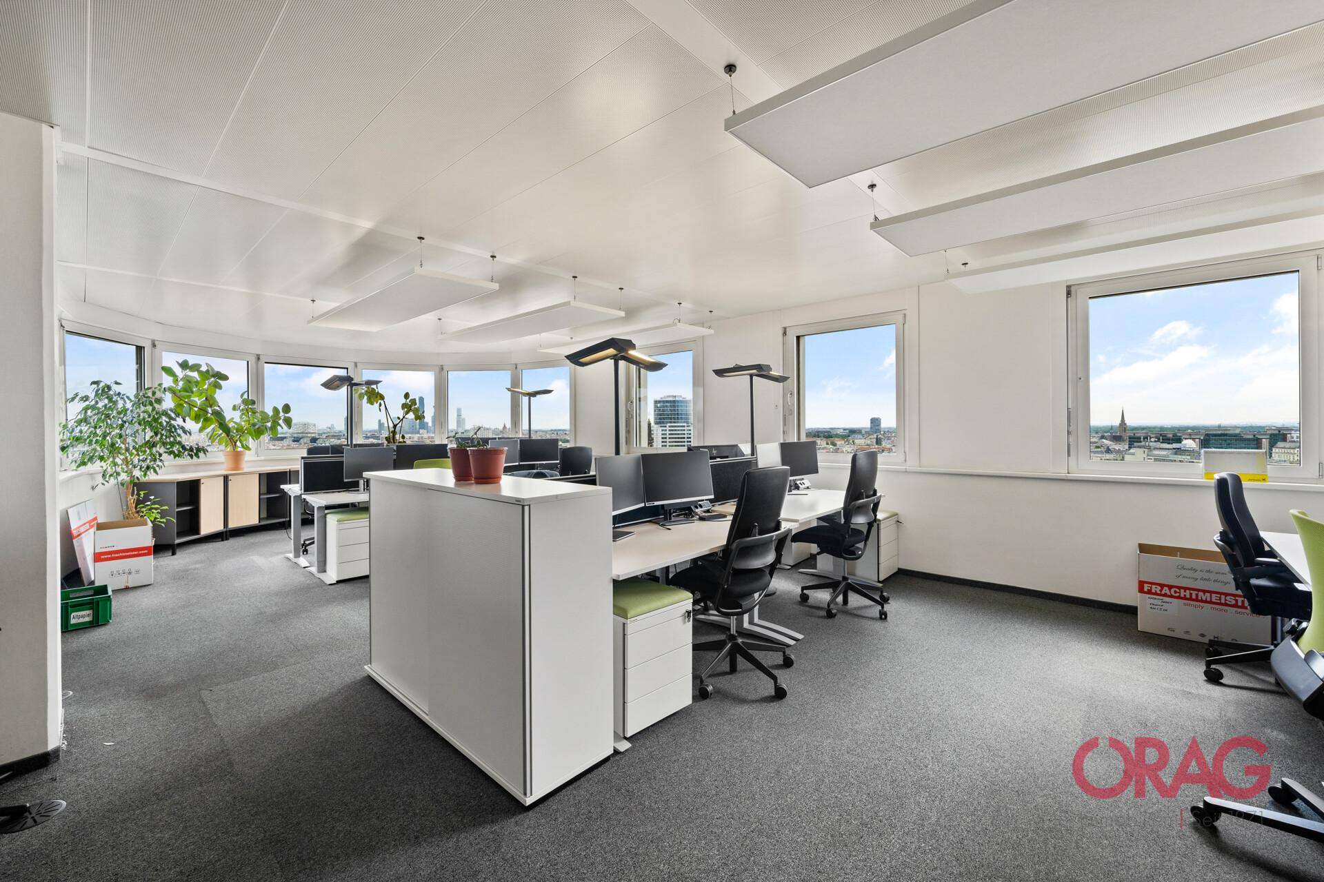 Geräumiges Büro mit mehreren Schreibtischen, ergonomischen Stühlen und weitem Ausblick.