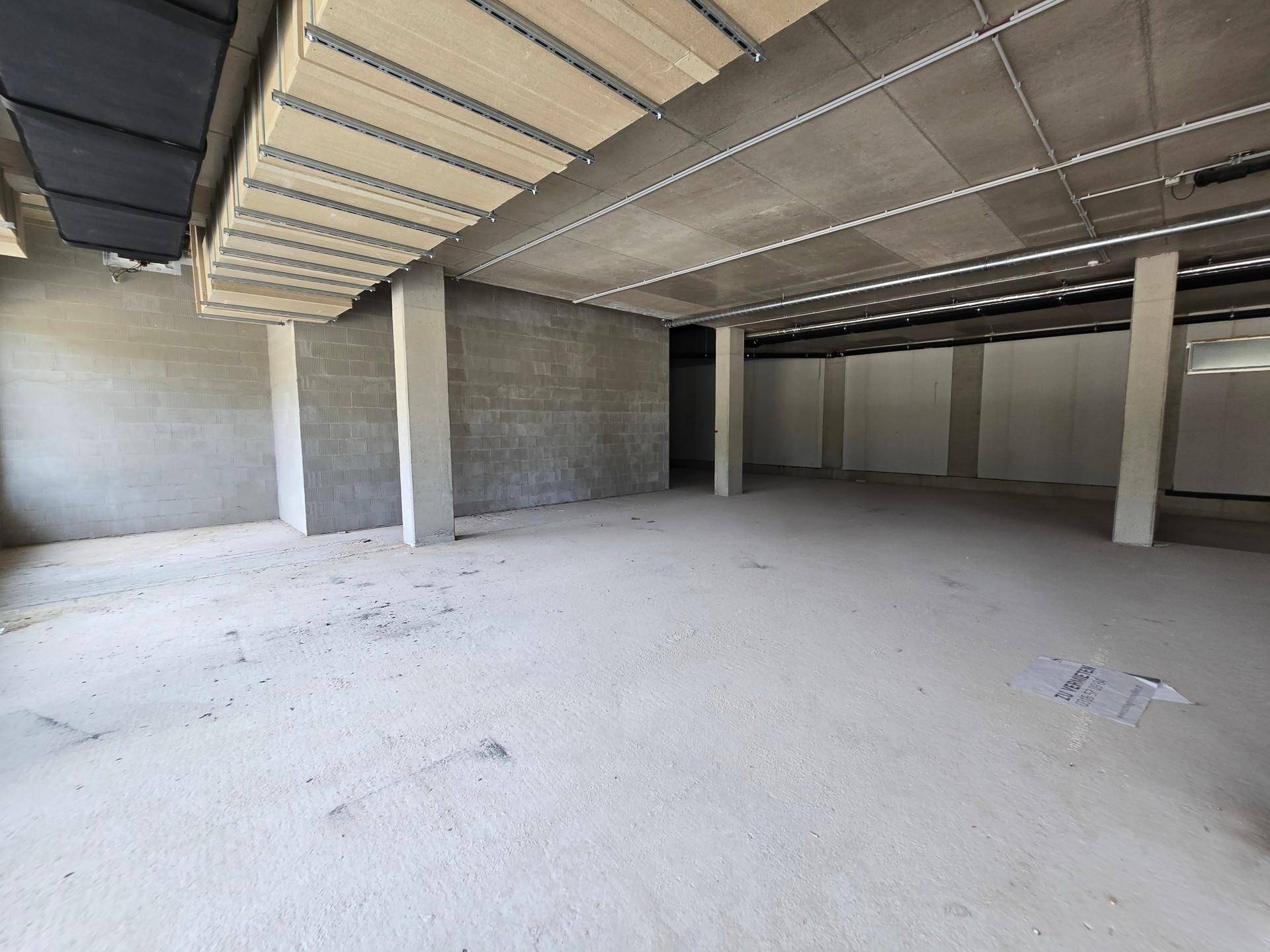 Unfertiger Gewerberaum mit Betonwänden und -decke, der auf den Innenausbau wartet.