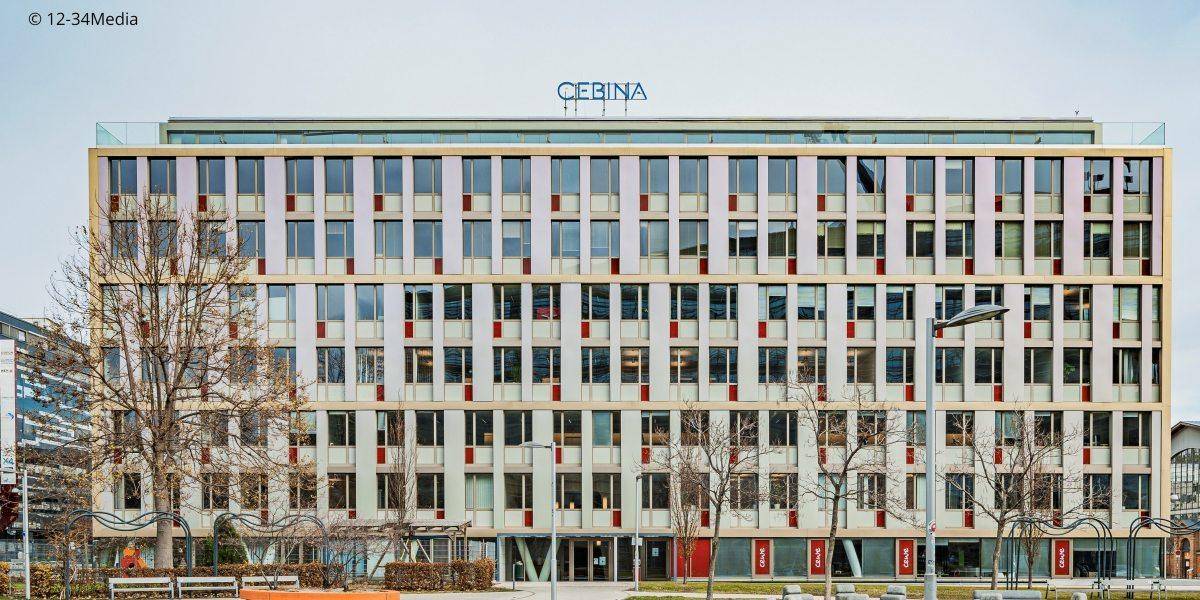 Moderne Gebäudefassade mit vielen Fenstern und dem Firmennamen "CEBINA" auf dem Dach.
