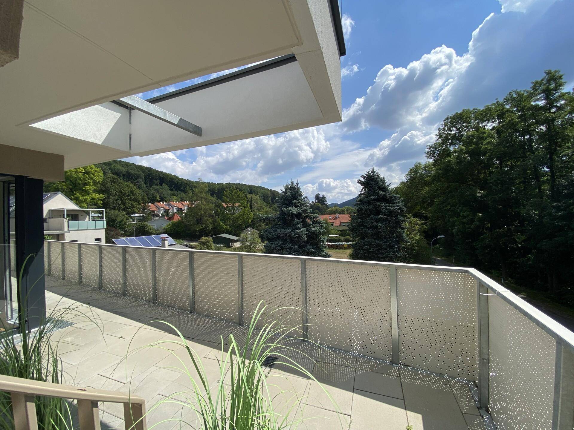 Weitläufige Terrasse mit Panoramablick über die Umgebung und grüne Hügel.