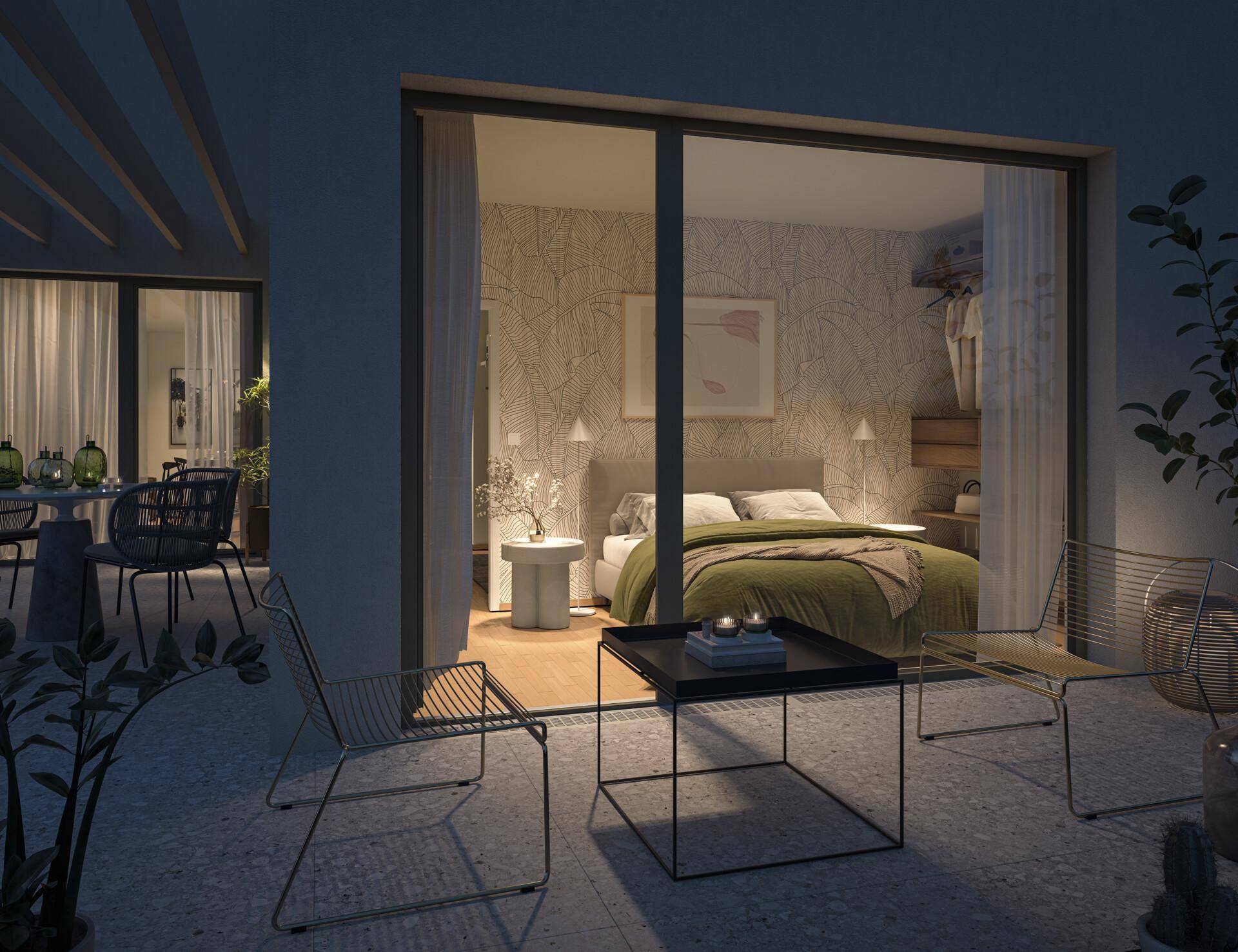 Gemütliche Terrasse am Abend mit Blick in ein modern eingerichtetes Schlafzimmer.