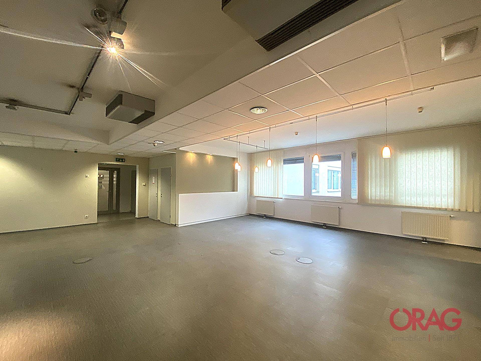 Großzügiger Bürobereich mit abgehängter Decke und modernen Hängelampen, bereit zur individuellen Gestaltung.