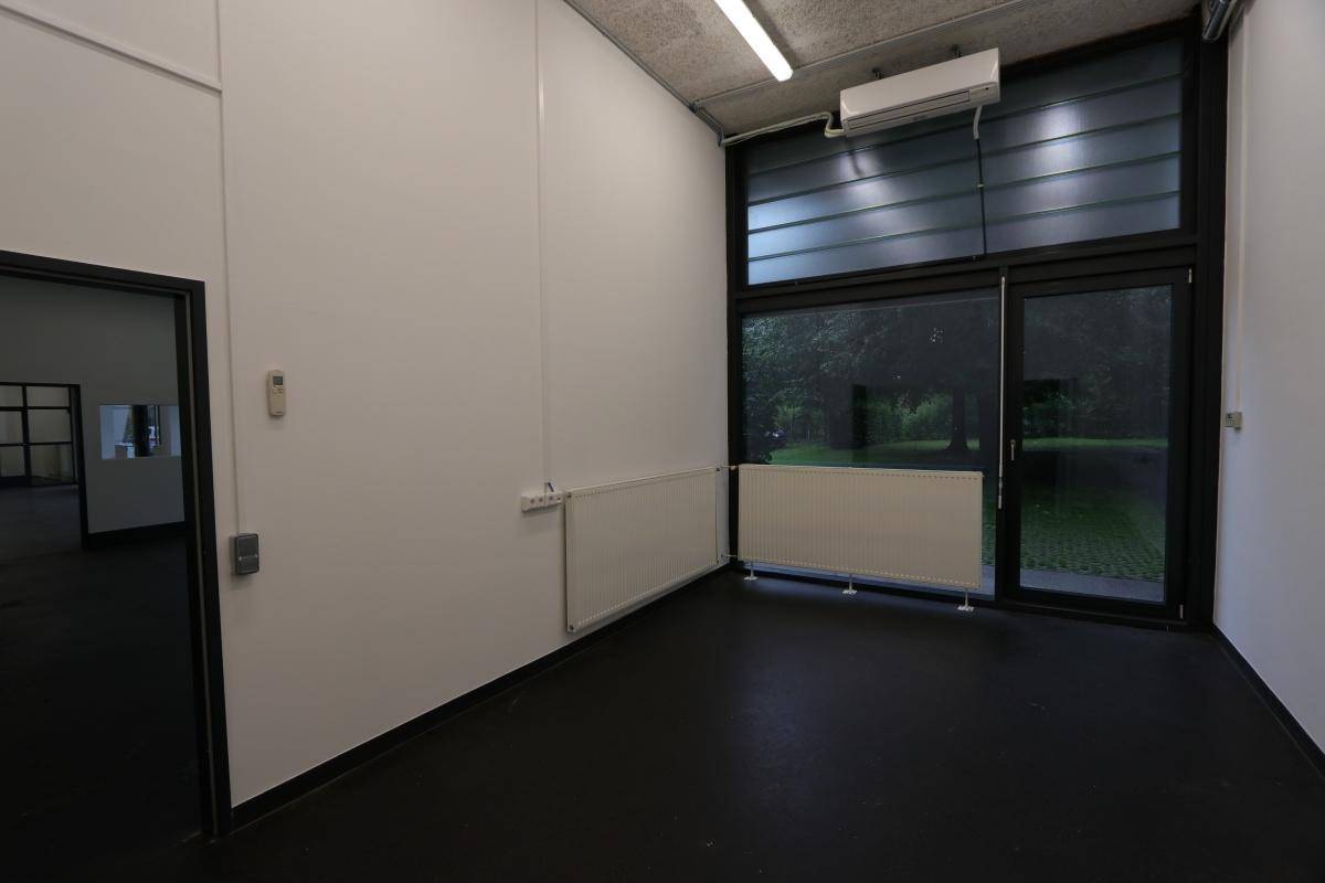 Kleiner, heller Raum mit großen Fenstern und Klimaanlage, ideal als Einzelbüro oder Lager.