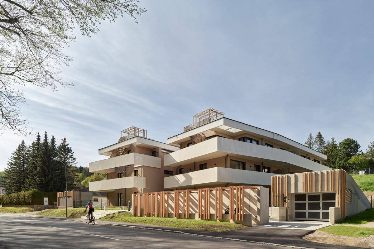 Neubau-Wohngebäude mit moderner Architektur, Tiefgaragenzufahrt und Holzverkleidung an der Fassade.
