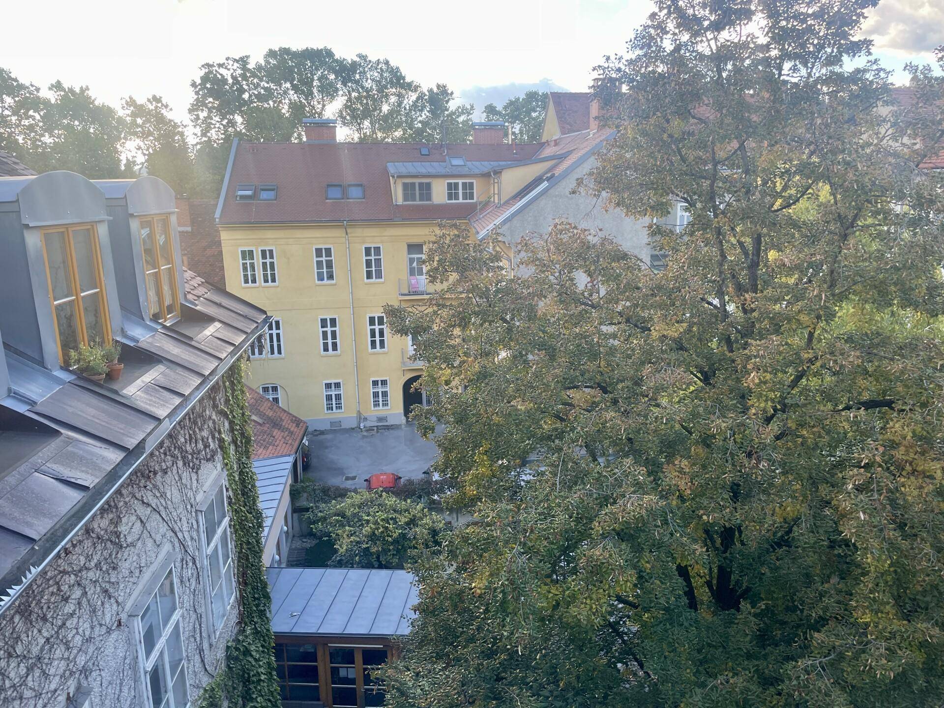 Malerischer Blick auf grüne Bäume und umliegende historische Gebäude von der Wohnung aus.