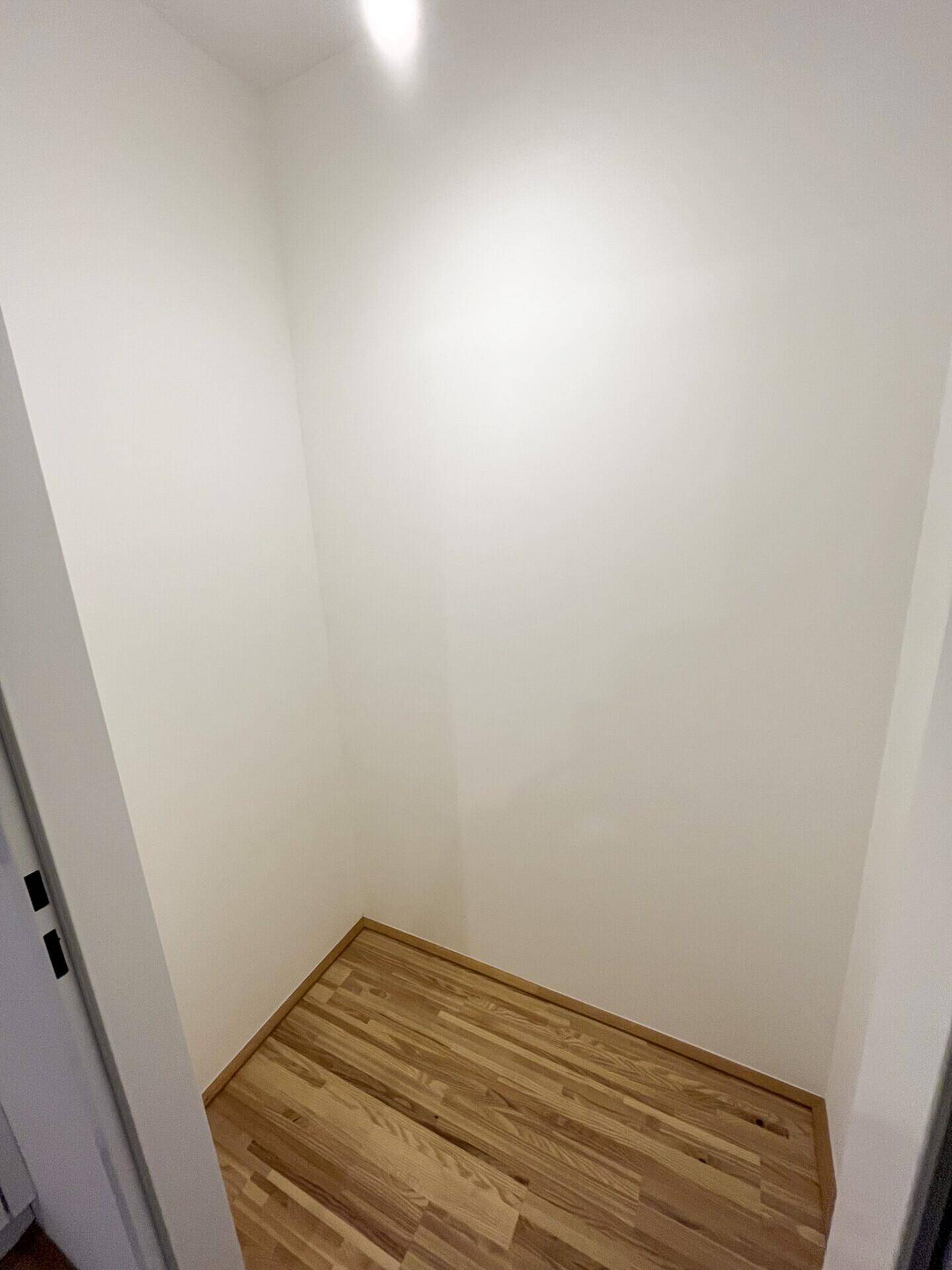 Kleiner Abstellraum mit Parkettboden und weißen Wänden, ideal für zusätzlichen Stauraum.
