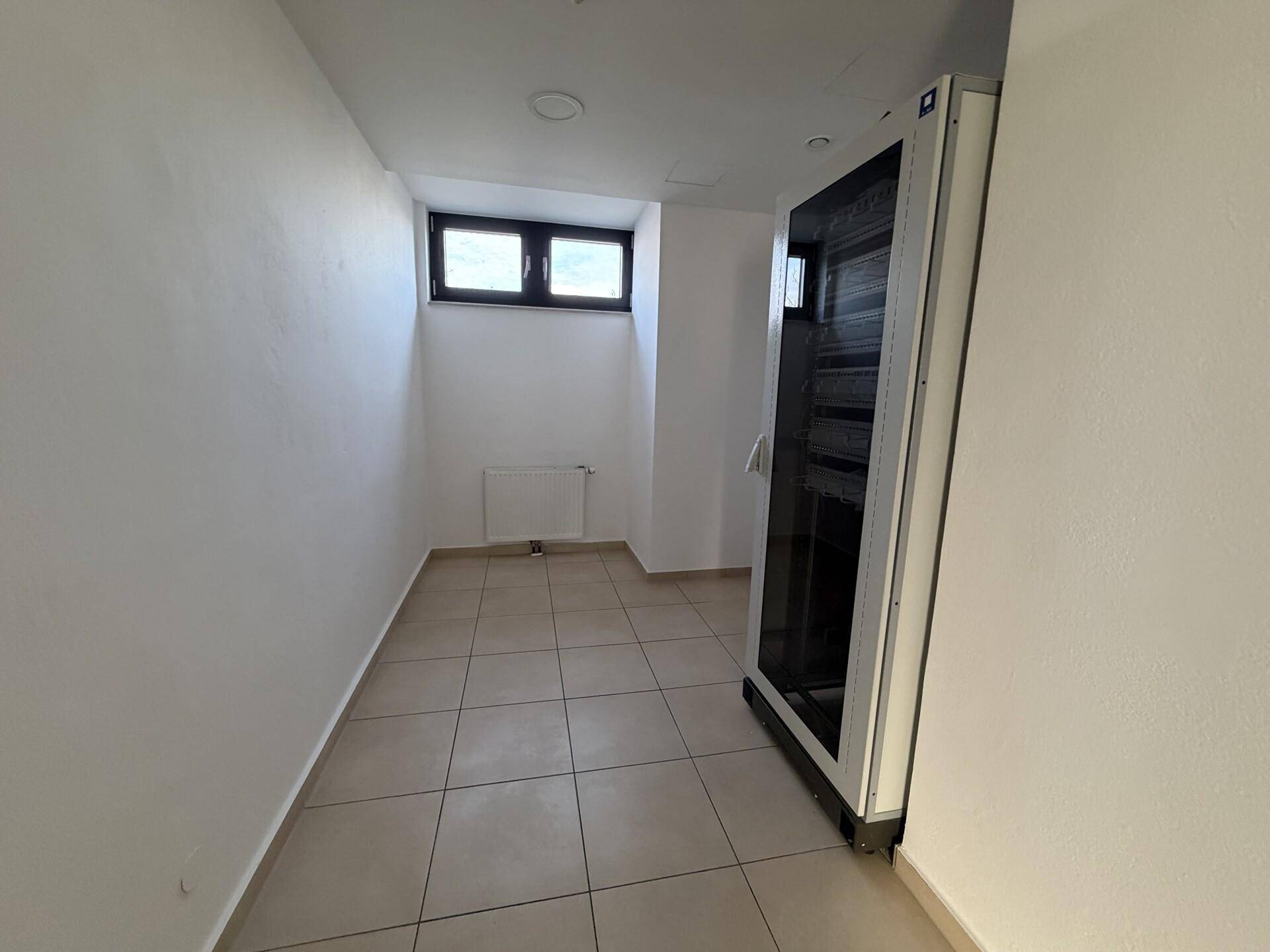 Kleiner Lagerraum oder Serverraum mit Fliesenboden, einem Fenster und einem Serverschrank.