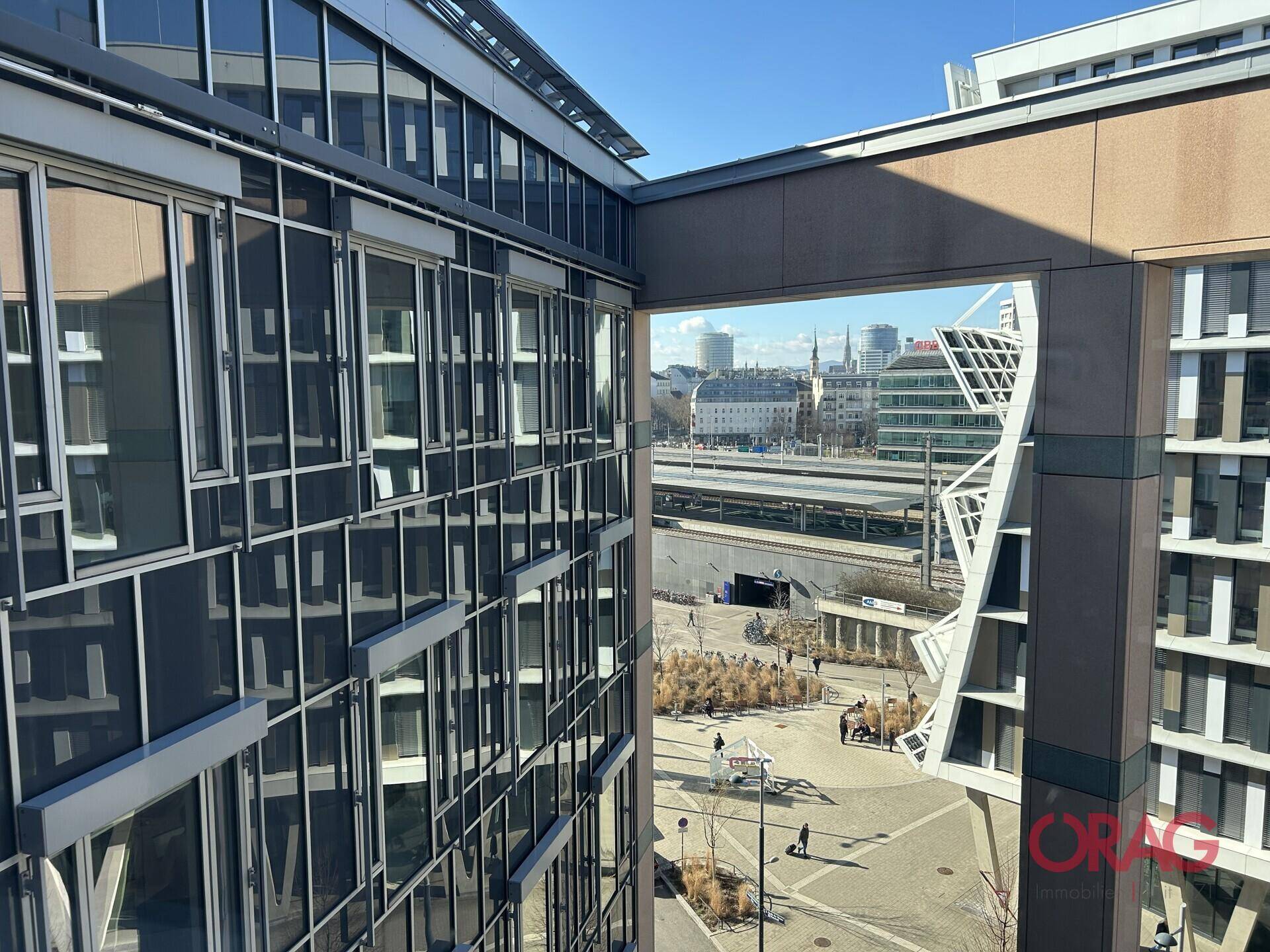 Blick von einem oberen Stockwerk auf die moderne Architektur des Gebäudes und die städtische Umgebung.