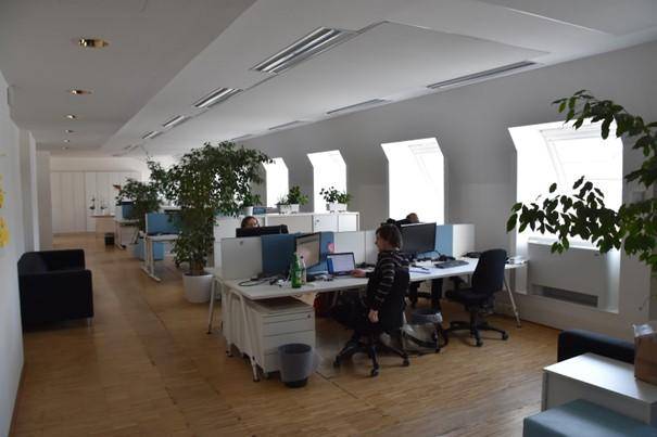 Helles Großraumbüro im Dachgeschoss mit mehreren Arbeitsplätzen und Dachfenstern.