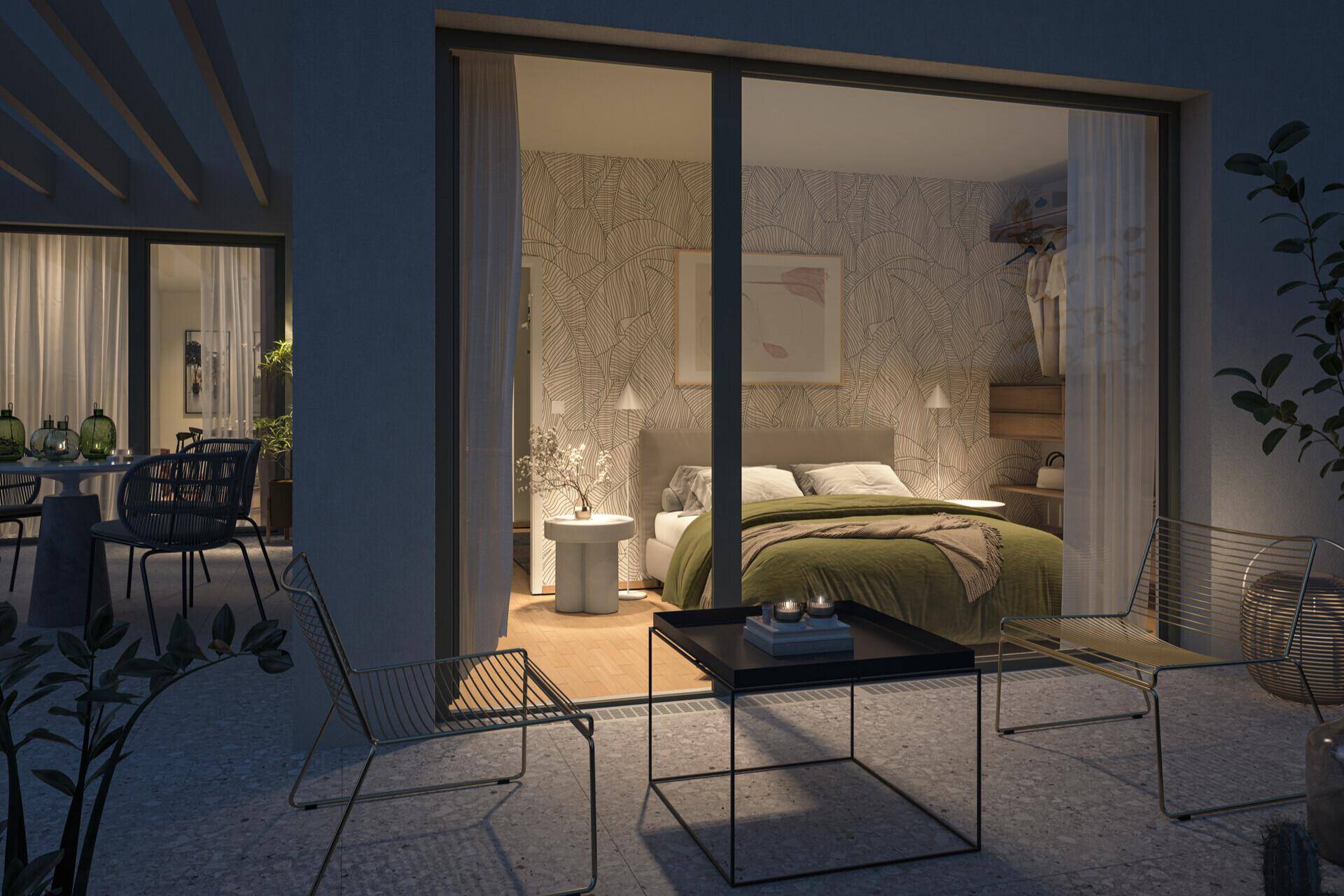 Gemütliches Schlafzimmer mit Doppelbett und Zugang zu einer privaten Terrasse am Abend.