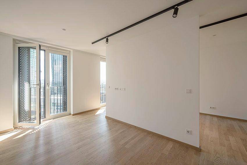 Heller, leerer Raum mit Parkettboden und Zugang zu einem französischen Balkon, ideal für individuelle Gestaltung.
