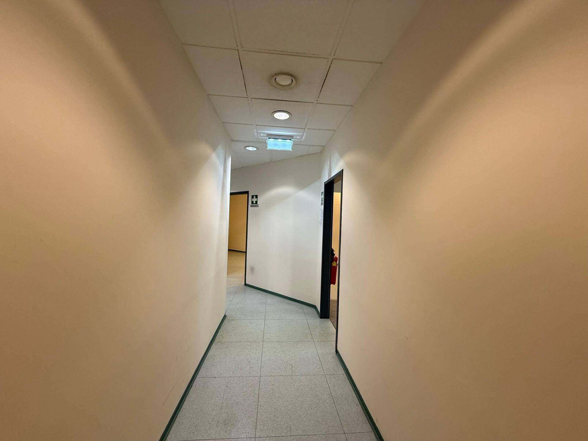 Langer, heller Flur mit Fliesenboden und Türen, der zu weiteren Räumen führt.