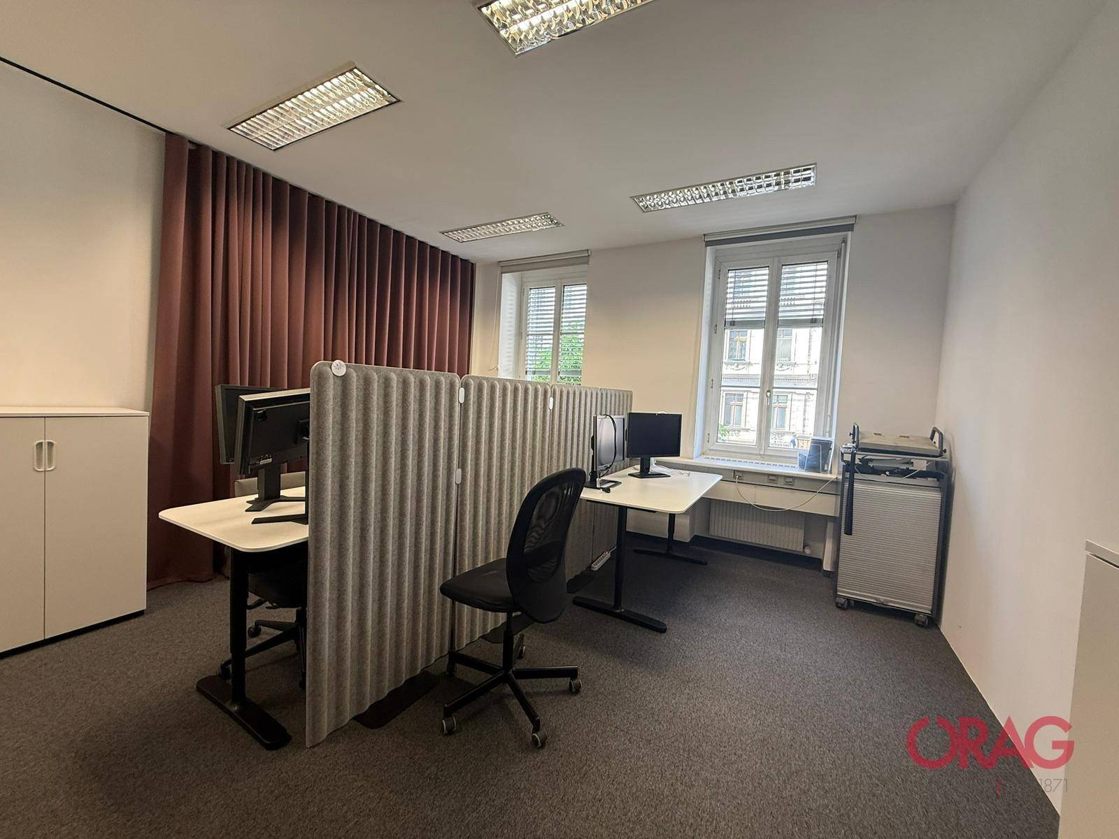 Modernes Büro mit zwei Arbeitsplätzen, Computern und schallabsorbierenden Trennwänden für konzentriertes Arbeiten.