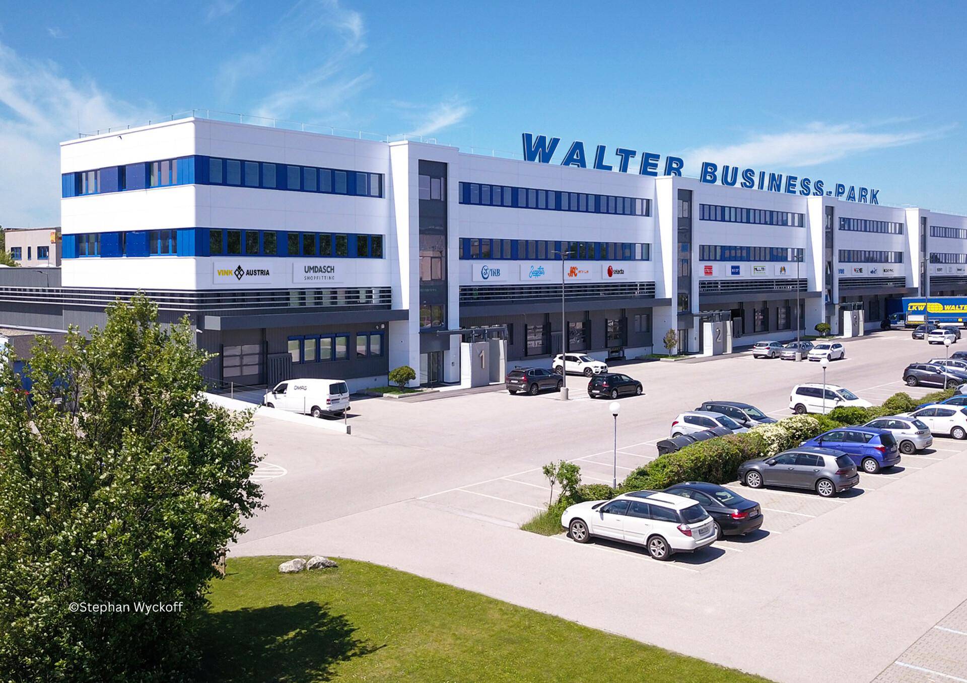 Panoramablick auf den Walter Business-Park mit mehreren Gebäudeteilen, Parkflächen und gepflegter Außenanlage.