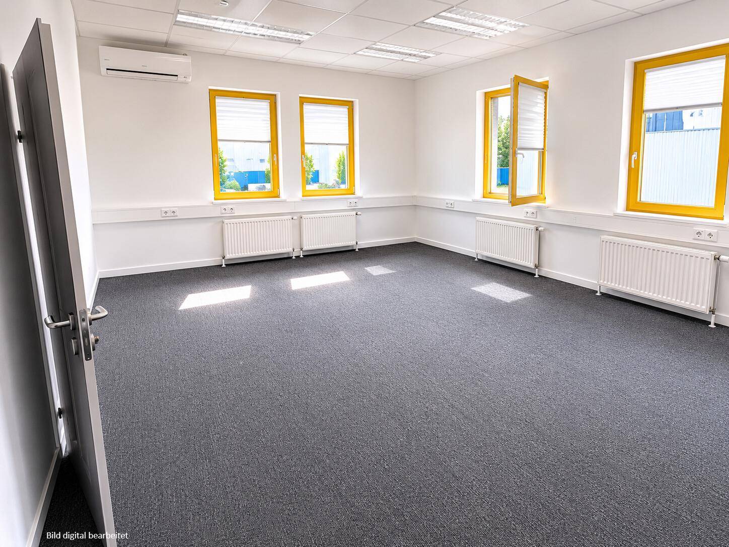 Geräumiges Büro mit Teppichboden, Klimaanlage und gelben Fensterrahmen, gut beleuchtet.