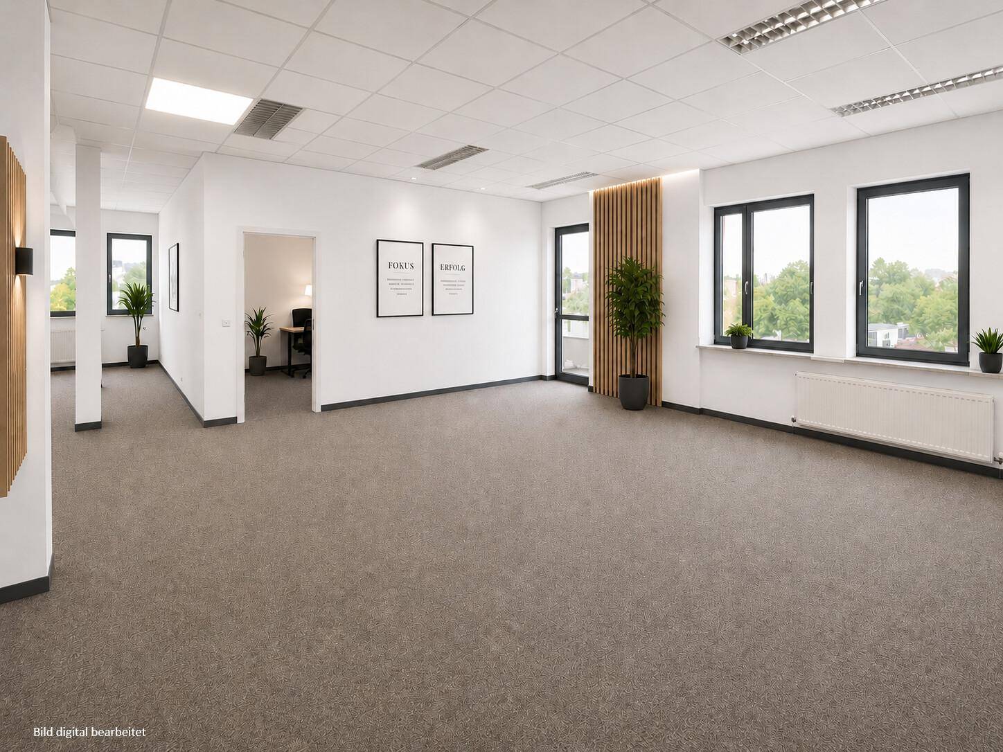 Modernes Großraumbüro mit Teppichboden, Holzakzenten und viel Tageslicht.