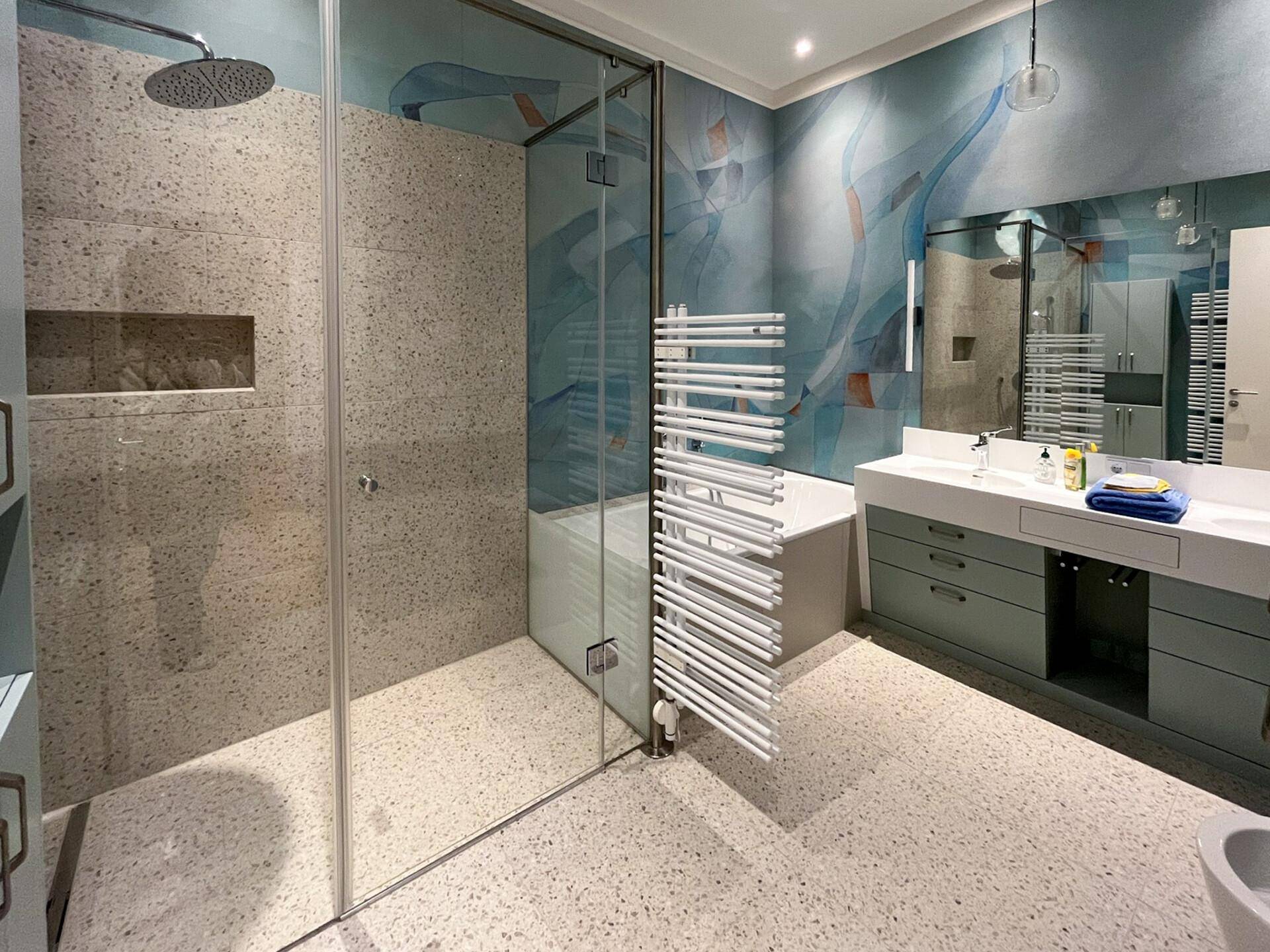 Modernes Badezimmer mit Doppelwaschbecken, großer Dusche und Badewanne, farbenfroh gestaltet.