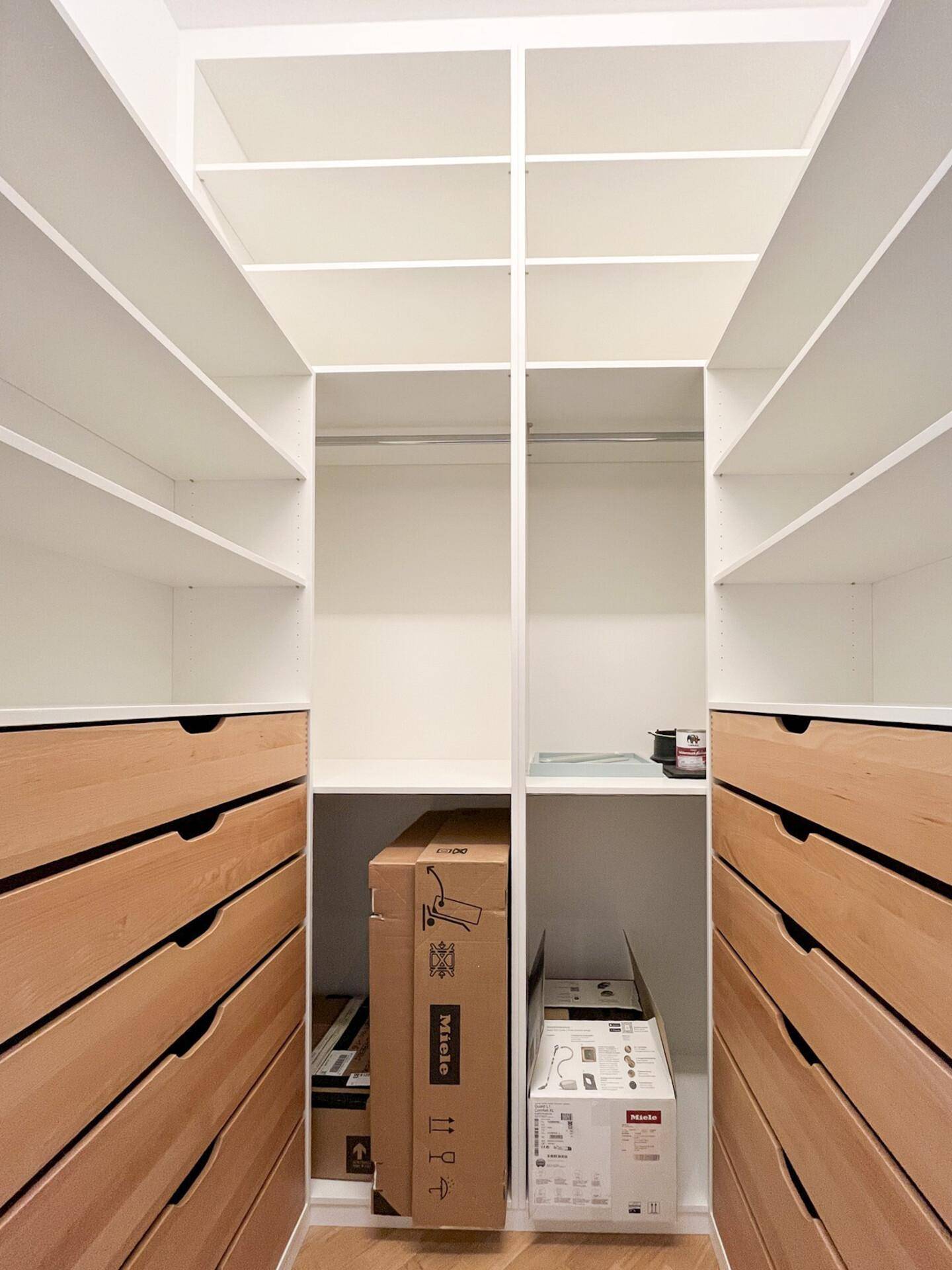 Geräumiger begehbarer Kleiderschrank mit vielen Regalen und Schubladen für optimale Organisation.