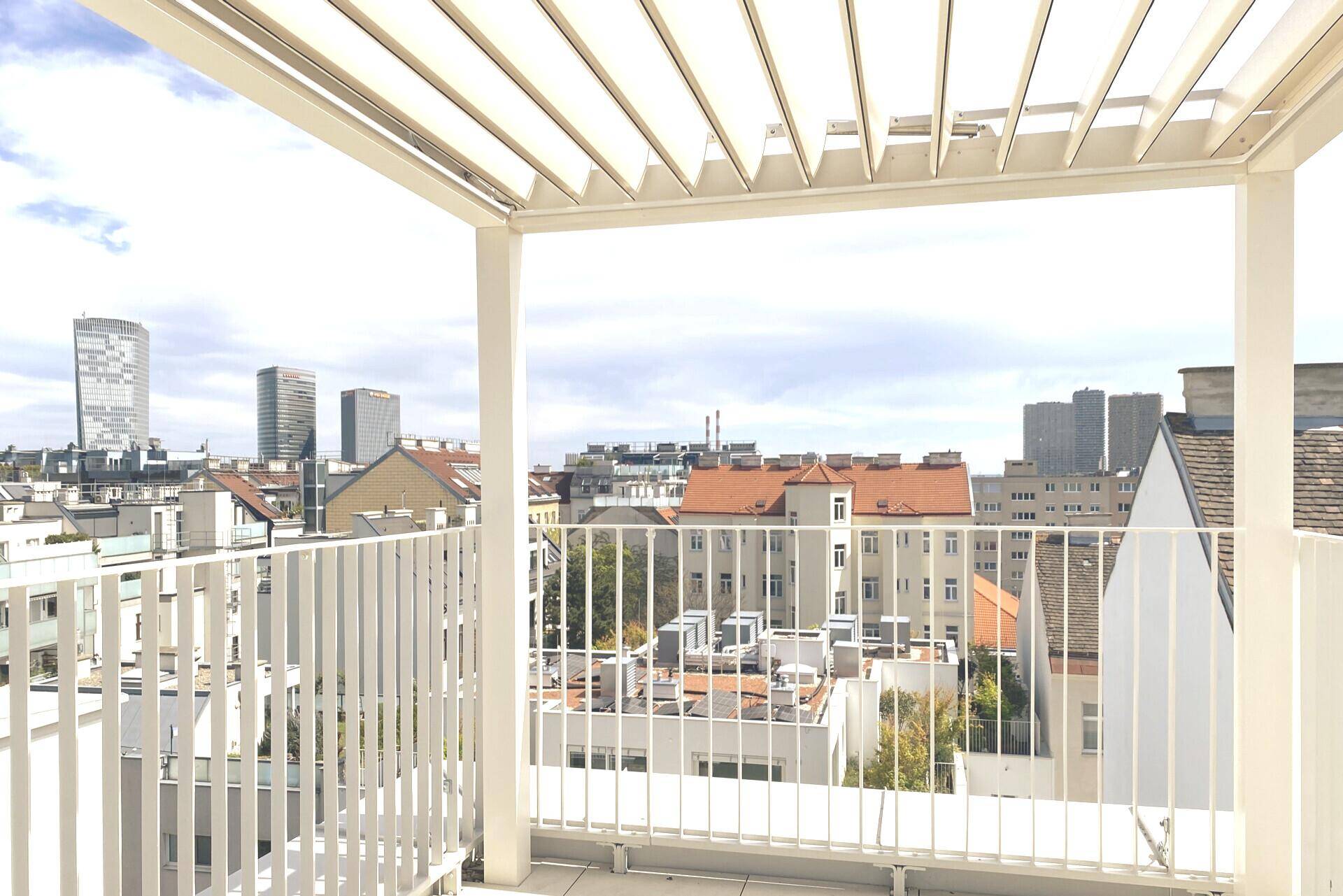Geräumige Dachterrasse mit moderner Pergola und weitem Blick über die Stadt.