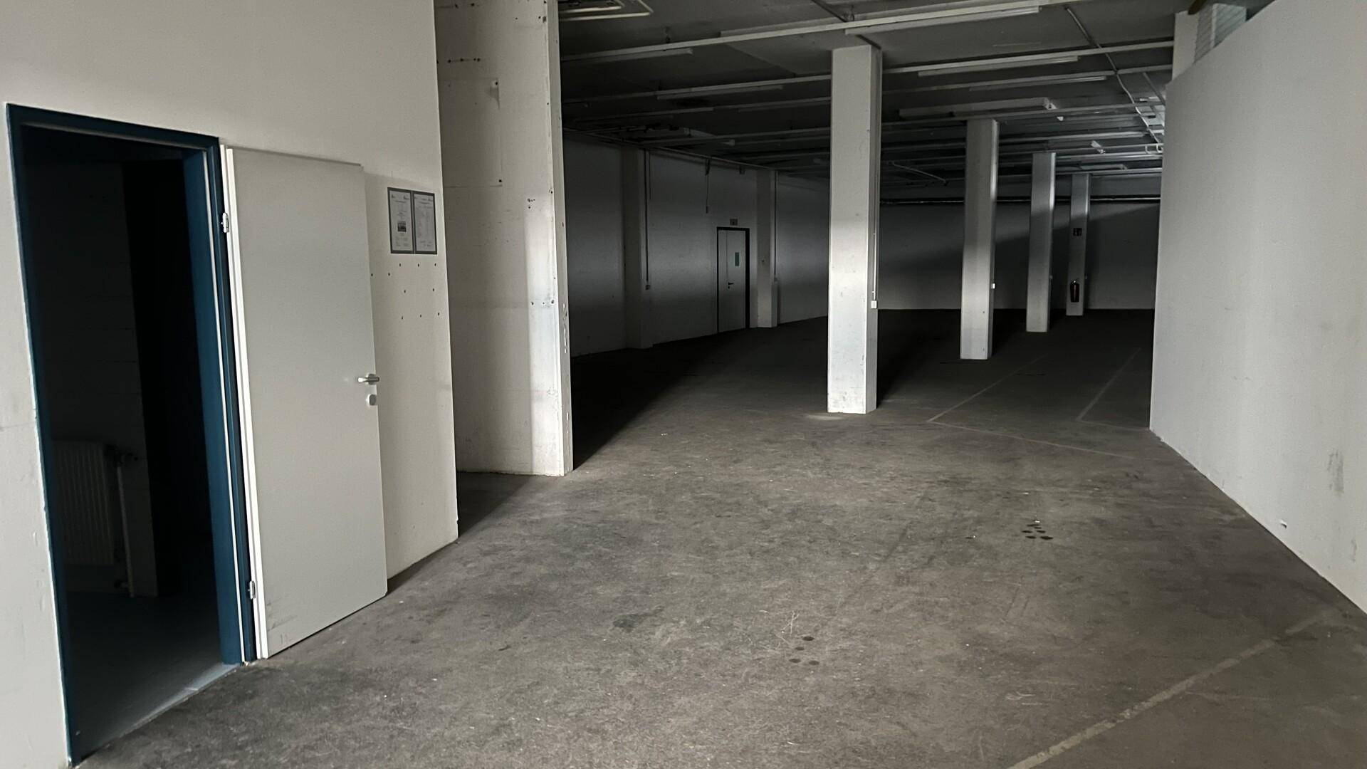 Weitläufiger Lagerbereich mit mehreren Säulen, Betonboden und Zugangstüren.