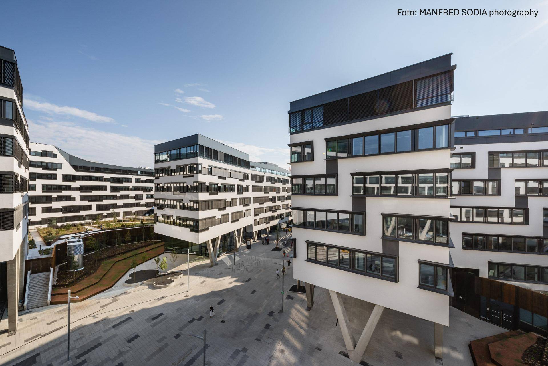 Außenansicht eines modernen Bürokomplexes mit markanter Architektur und großen Fensterfronten.