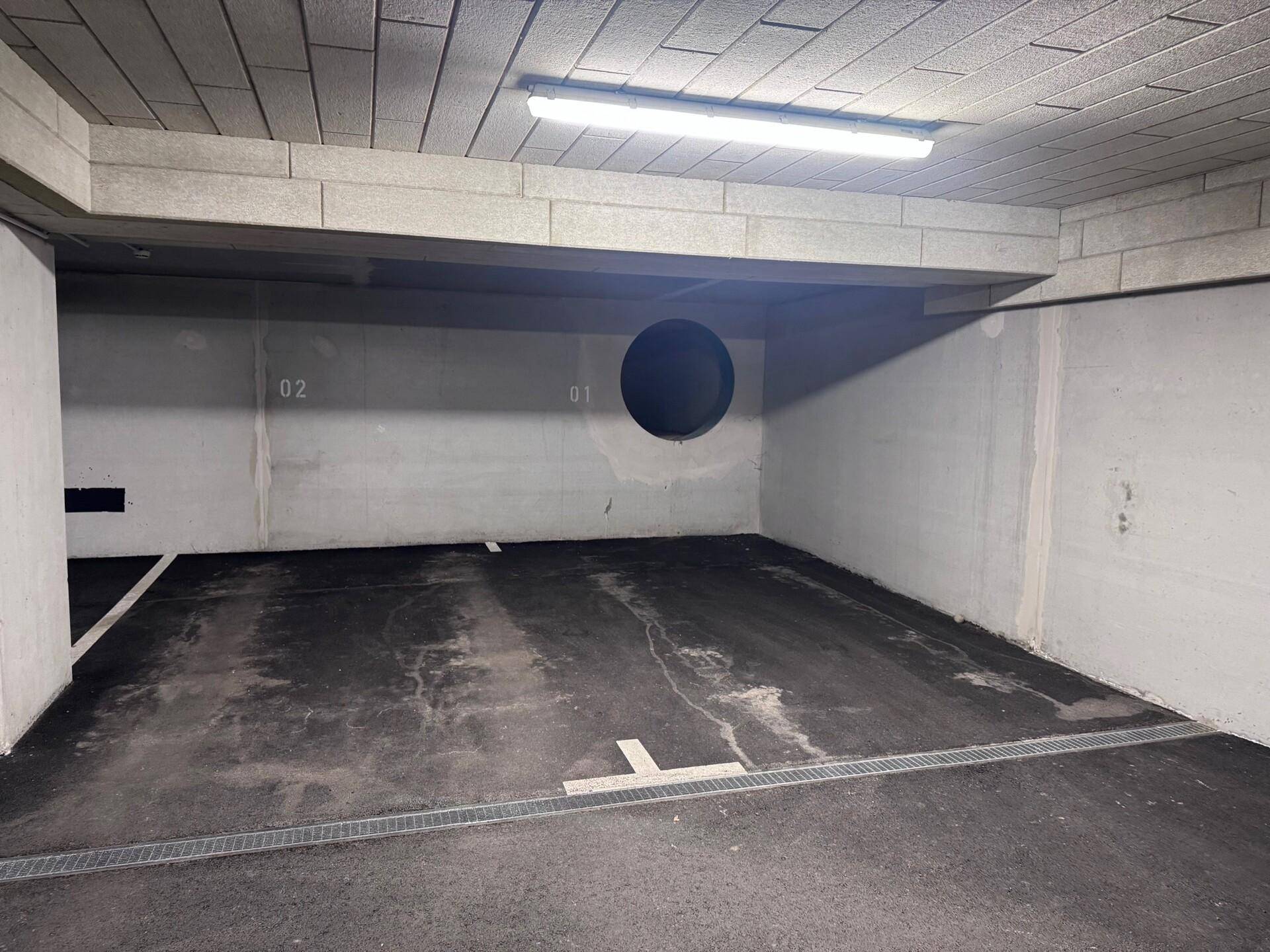 Leerer Tiefgaragenstellplatz mit Betonwänden und Decke in gutem Zustand.